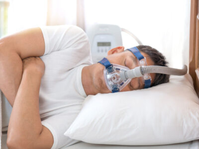 Man sleeping in bed wearing CPAP mask ,sleep apnea therapyHappy