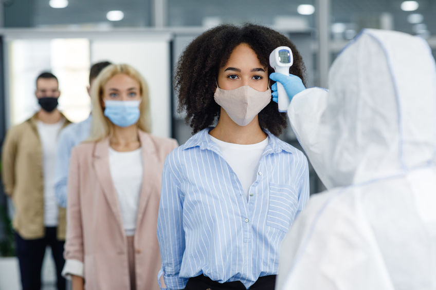 Checking temperature of multiracial workers in protective masks with infrared thermometer, cpap covid covid19
